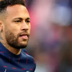 Neymar w charakterystycznych fryzurach, z kolczykami i tatuażami, w granatowej bluzie z napisem "PARIS".