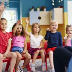 Dzieci na zajęciach w przedszkolu podnoszą ręce. Czy zerówka jest obowiązkowa w Polsce? Tak, od 2022 roku.