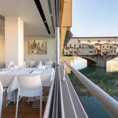 Tavoli apparecchiati con vista sul Ponte Vecchio: un'idea su dove mangiare a Firenze.