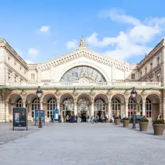 Prachtvoller Bahnhof in Paris Zentrum mit Bögen und einer großen Uhr.