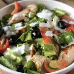 Insalata di pollo sfiziosa con lattuga croccante, pomodoro, olive nere e un dressing cremoso. Perfetta per un pasto leggero e gustoso.