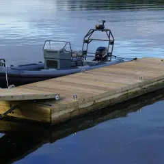 En nybyggd brygga med en ribbåt förtöjd. Perfekt för att njuta av sommaren vid vattnet.