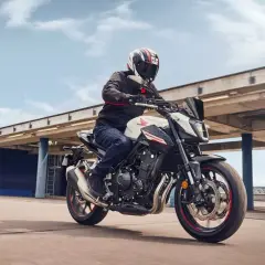 Hombre en moto Honda Hornet blanca y negra, con casco, acelerando. El motor de la moto ratea al acelerar, pero la experiencia es emocionante.