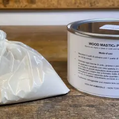 Sacchetto di stucco in polvere e barattolo di stucco per legno. Istruzioni su come si prepara lo stucco in polvere: mescolare 3 parti di polvere con 1 parte d'acqua.