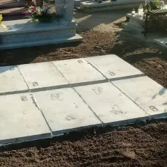 Rozpoczęcie prac nad wykonaniem piwniczki na cmentarzu. Betonowe płyty ułożone na ziemi, gotowe do dalszych etapów budowy.