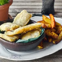 Knusprige Fischstücke in Tempurateig, daneben Pommes Frites. Ein Genuss, der zeigt, was ist Tempurateig.