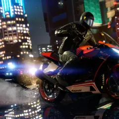 Motocyklista w kasku ucieka przed radiowozem policyjnym w nocnym mieście.