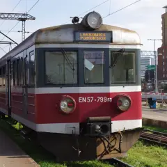 Pociąg EN57-799ra z napisem LASKOWICE POMORSKIE na tablicy. Stoi na peronie, w tle budynki i trakcje kolejowe.