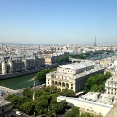 Vue panoramique de Paris, zone 1 à 3, avec la Seine, des bâtiments historiques et la Tour Eiffel au loin.