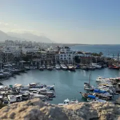 Port z licznymi łodziami i żaglówkami, w tle miasto i góry. Piękna, słoneczna pogoda na Cyprze w listopadzie.