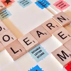 Litery na planszy do gry układają się w słowa "SCHOOL", "LEARN", "MATH". Czy angielski jest trudny? Zależy od tego, jak się uczysz!