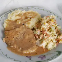Mięciutki schab w sosie, podany z purée ziemniaczanym i surówką z kapusty. Pyszny obiad gotowy!