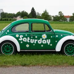 Zielony Garbus z napisem "Saturday" i stokrotkami, idealny na dzień wolny za święto w sobotę.