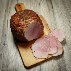 Wędzonka na desce, pokrojona w plastry. Idealna temperatura mięsa w środku podczas wędzenia to klucz do sukcesu.