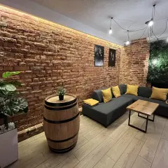 Przytulny lokal na 18 urodziny w Lublinie. Ceglana ściana, wygodna kanapa i beczka jako stolik tworzą niepowtarzalny klimat.