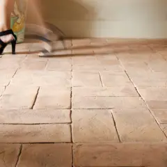 Piedi con sandali neri su un pavimento in cotto. Impara come pulire pavimento in cotto molto sporco per un risultato impeccabile.