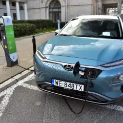 Niebieski Hyundai Kona ładuje się na stacji. To przyszłość, gdy skończy się produkcja aut spalinowych.