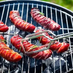 A pyszna kiełbasa na grila, rumiana i soczysta, z gałązkami rozmarynu, pieczona na węglu.