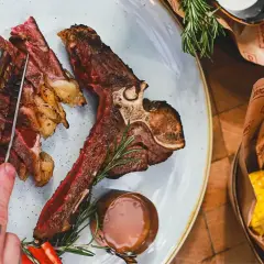 Idealne jakie wino do wołowiny? Soczysty stek T-bone z pieczonymi ziemniakami i kukurydzą.