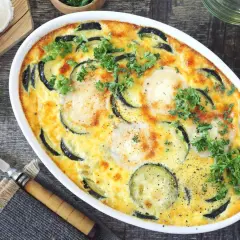 Clafoutis courgettes aux chèvres, garni de persil frais, prêt à être dégusté. Un délice simple et savoureux.