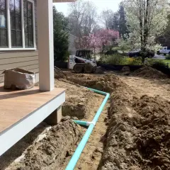 Bauarbeiten am Haus: Ein Bobcat-Lader und ein Bagger sind im Einsatz, um Rohre für die Drainage zu verlegen.