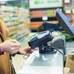 Une femme paie avec sa carte Visa. Si vous avez besoin de savoir comment annuler un paiement par carte Visa, contactez votre banque.
