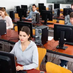 Uczniowie rozwiązują najtrudniejsze pytania na prawo jazdy w sali komputerowej.