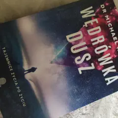 Okładka książki "Wędrówka dusz" Dr Michaela Newtona. Sylwetka człowieka na tle kosmicznego krajobrazu.