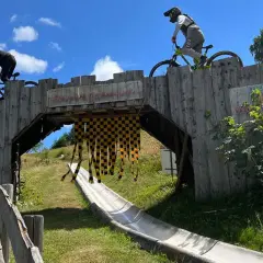 Två cyklister på en träbro i en bikepark i Tyskland. En perfekt plats för en äventyrlig semester.