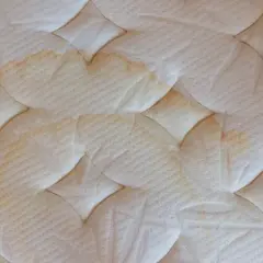 Manchas amarillas en un colchón blanco, indicando la necesidad de limpiar colchón pis niño.