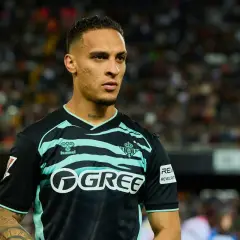 Piłkarz w czarno-miętowej koszulce z logo GREE, być może Antony, czeka na swój transfer.
