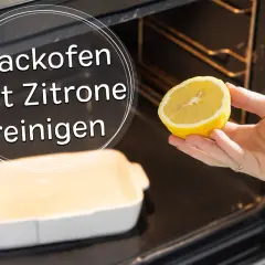 Eine Hand hält eine Zitronenhälfte, um den Backofen zu reinigen. Ein weißes Auflaufform steht bereit.