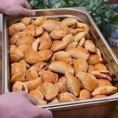 Taca pełna złocistych pasztecików z mięsem, gotowych do podania.