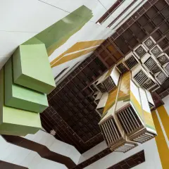 Geometryczne formy i kolory tworzą unikalną przestrzeń. Ta fotografia architektury ukazuje wnętrze z perspektywy od dołu.
