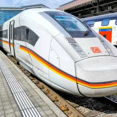 Moderner ICE train mit Deutschlandfarben am Bahnhof. Daneben ein SBB CFF FFS Zug.