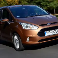 Brązowy Ford B-Max jedzie po drodze, za nim drzewa w jesiennych barwach.