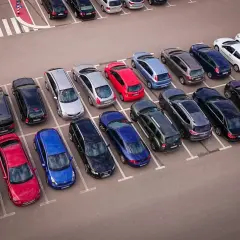 Wspólnota mieszkaniowa pilnuje porządku, by uniknąć mandatu za parkowanie. Wiele samochodów na parkingu.