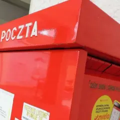 Czerwona skrzynka pocztowa z napisem "POCZTA". Warto pamiętać o poprawnym wpisaniu kodu pocztowego Toruń, aby list trafił do adresata.