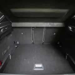 Pusta przestrzeń bagażowa Peugeot 3008, z widocznym gaśnicą. Wymiary bagażnika pozwalają na przewóz wielu rzeczy.
