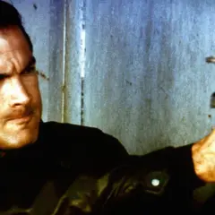 Steven Seagal jako Nico, policjant z filmu "Nico - ponad prawem", celuje z pistoletu.