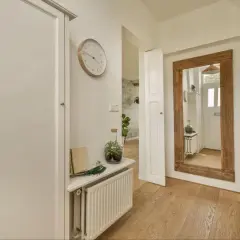 Duże lustro i jasne kolory pomagają rozjaśnić wąski korytarz. Zobacz, jak to zrobić!