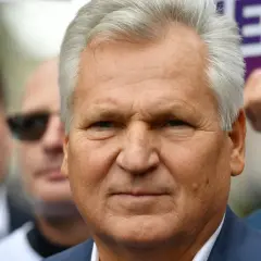 Aleksander Kwaśniewski, były prezydent, w otoczeniu ludzi. Jego prezydentura to ważny rozdział w historii Polski.