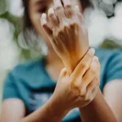 Mano che si tiene il polso, forse per un dolore ai legamenti del polso.