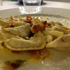 Pyszne pierożki z ricottą i szpinakiem, posypane parmezanem. Idealne pytanie: co zjeść w Bergamo?