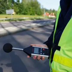 Policjant mierzy poziom hałasu. Sprawdza, ile decybeli może mieć auto, by nie przekraczać norm.