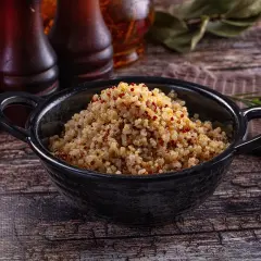 Quinoa cotta in una ciotola nera, pronta per essere gustata. Ecco come cuocere la quinoa per un piatto sano e gustoso.
