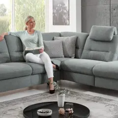 Frau liest auf einem gemütlichen Ecksofa mit verstellbaren Kopfstützen. Die tiefe **sitztiefe sofa** lädt zum Entspannen ein.