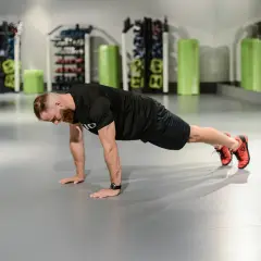 Mężczyzna wykonuje pompkę. Dowiedz się, co dają pompki dla siły i wytrzymałości.