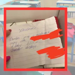 Ręcznie napisana prośba o zwolnienie z lekcji na kartce w kratkę, w tle szkolna sala.