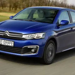 Niebieski Citroen C-Elysée jedzie po drodze, rozmyte tło sugeruje ruch.